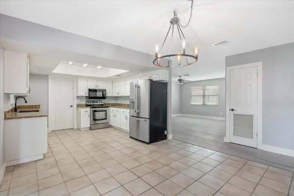 a kitchen with a refrigerator a sink and a stove top oven