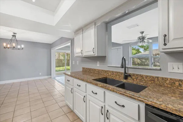 a kitchen with granite countertop a sink a stove and cabinets