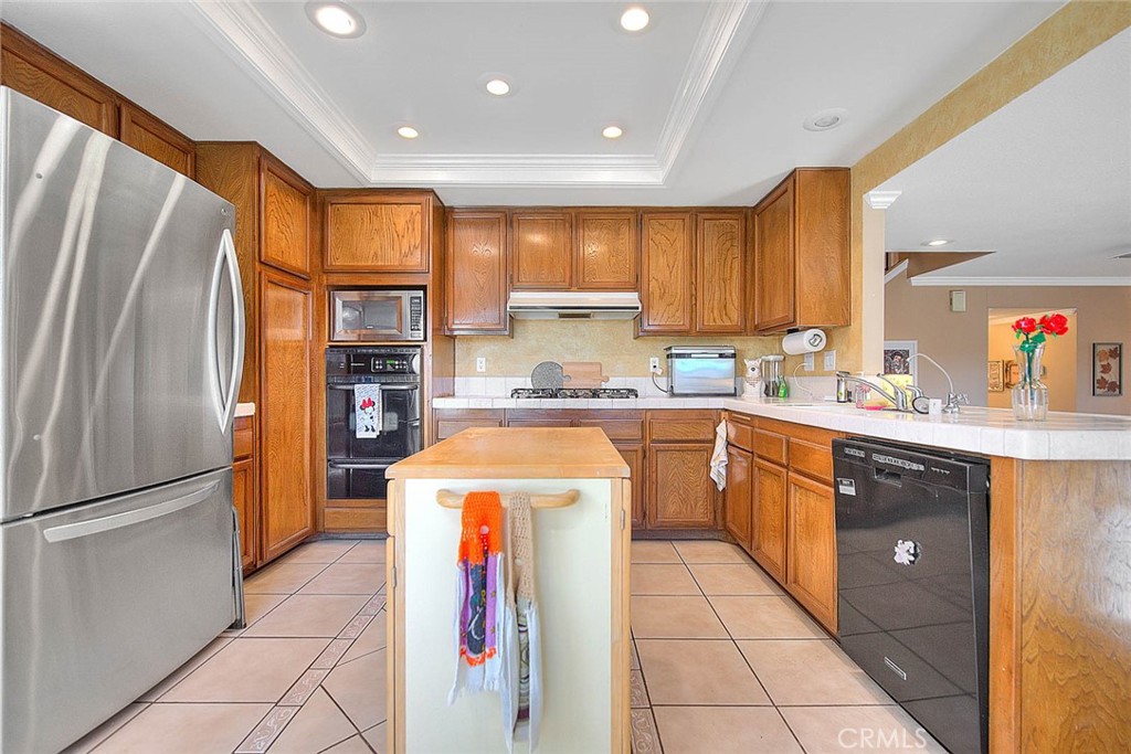 32 Rising Hill Road Phillips Ranch, CA 91766 - Photo 10 of 63 a kitchen with stainless steel appliances granite countertop a refrigerator a sink and a stove