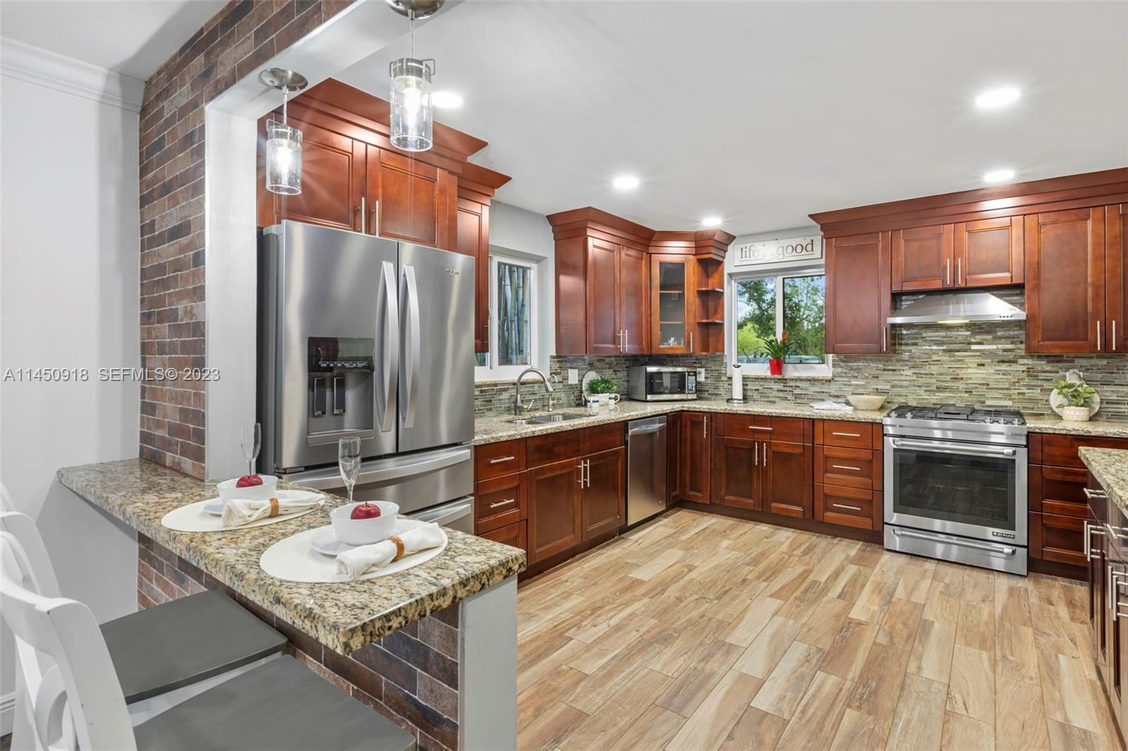 6410 Melaleuca Road Southwest Ranches, FL 33330 - Photo 11 of 50 a kitchen with stainless steel appliances granite countertop a sink stove and refrigerator