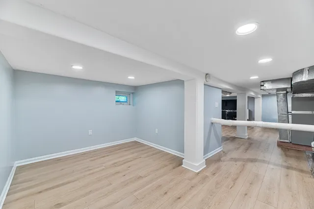 a view of a big room with wooden floor and windows