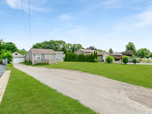 a view of a house with a big yard plants and large trees