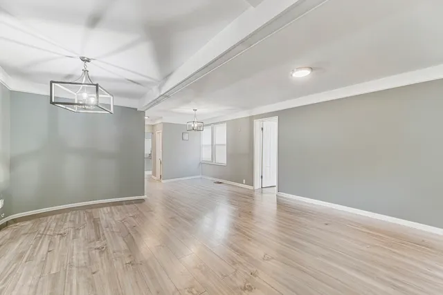 a view of an empty room with wooden floor