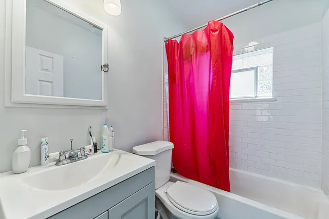 a bathroom with a sink a toilet and shower curtain