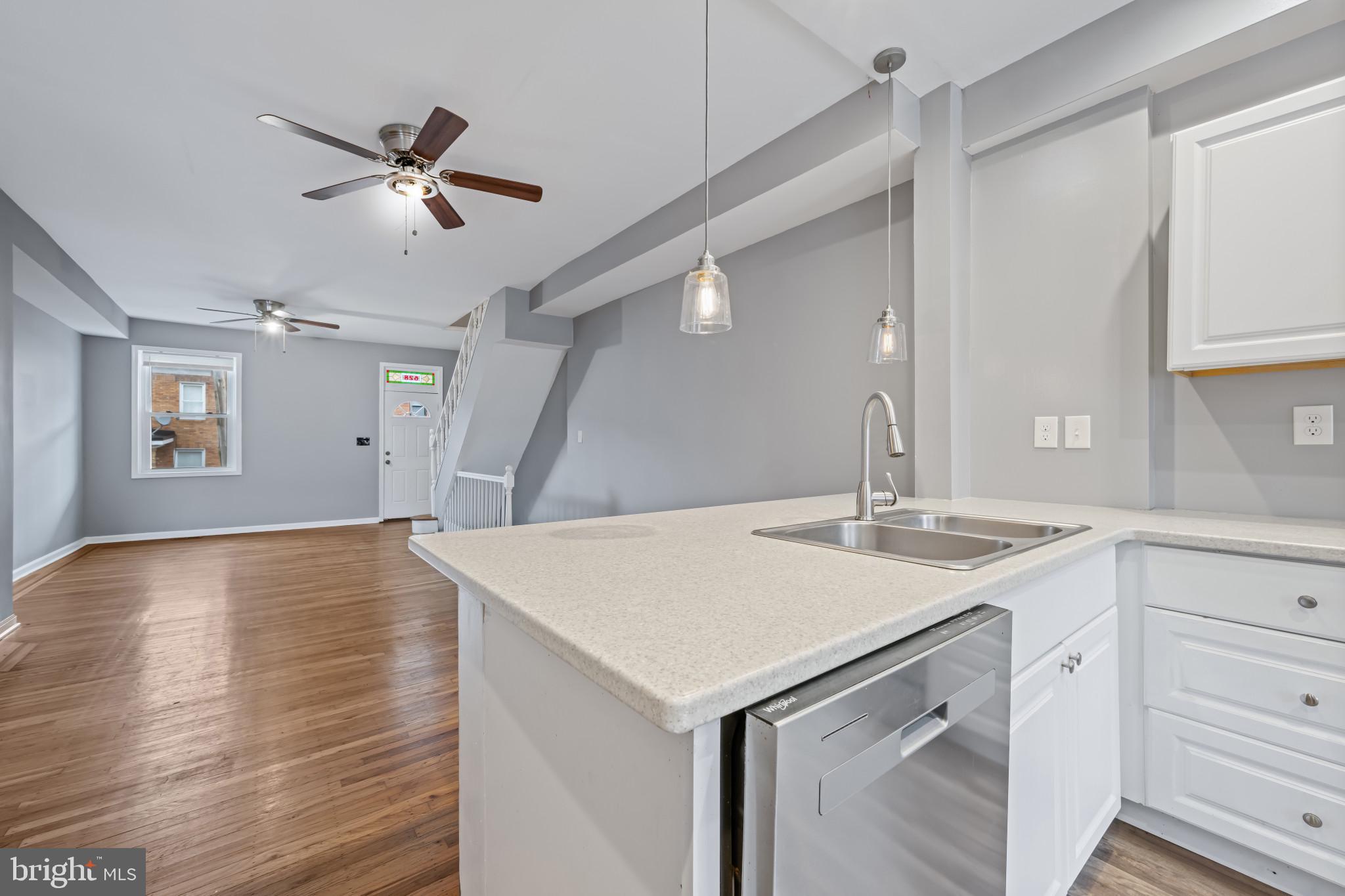 628 Savage Street Baltimore, MD 21224 - Photo 10 of 45 a view of a kitchen island a sink and dishwasher with wooden floor