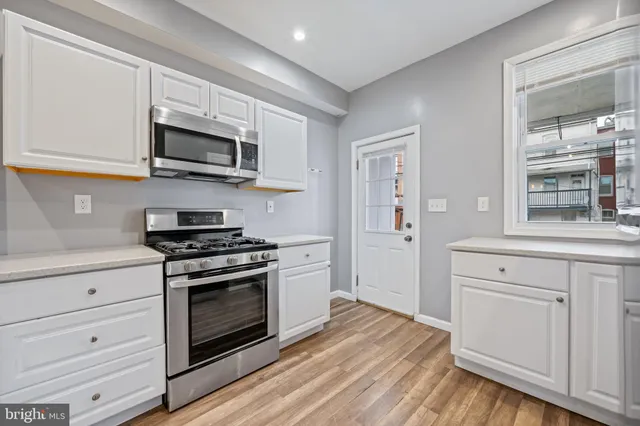 a view of a kitchen island a sink and dishwasher with wooden floor