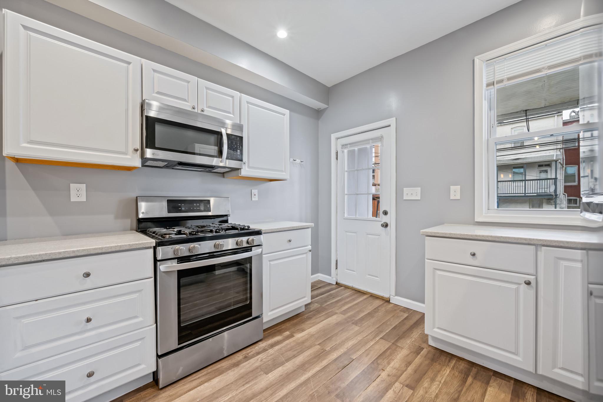 628 Savage Street Baltimore, MD 21224 - Photo 11 of 45 a kitchen with stainless steel appliances white cabinets and stove