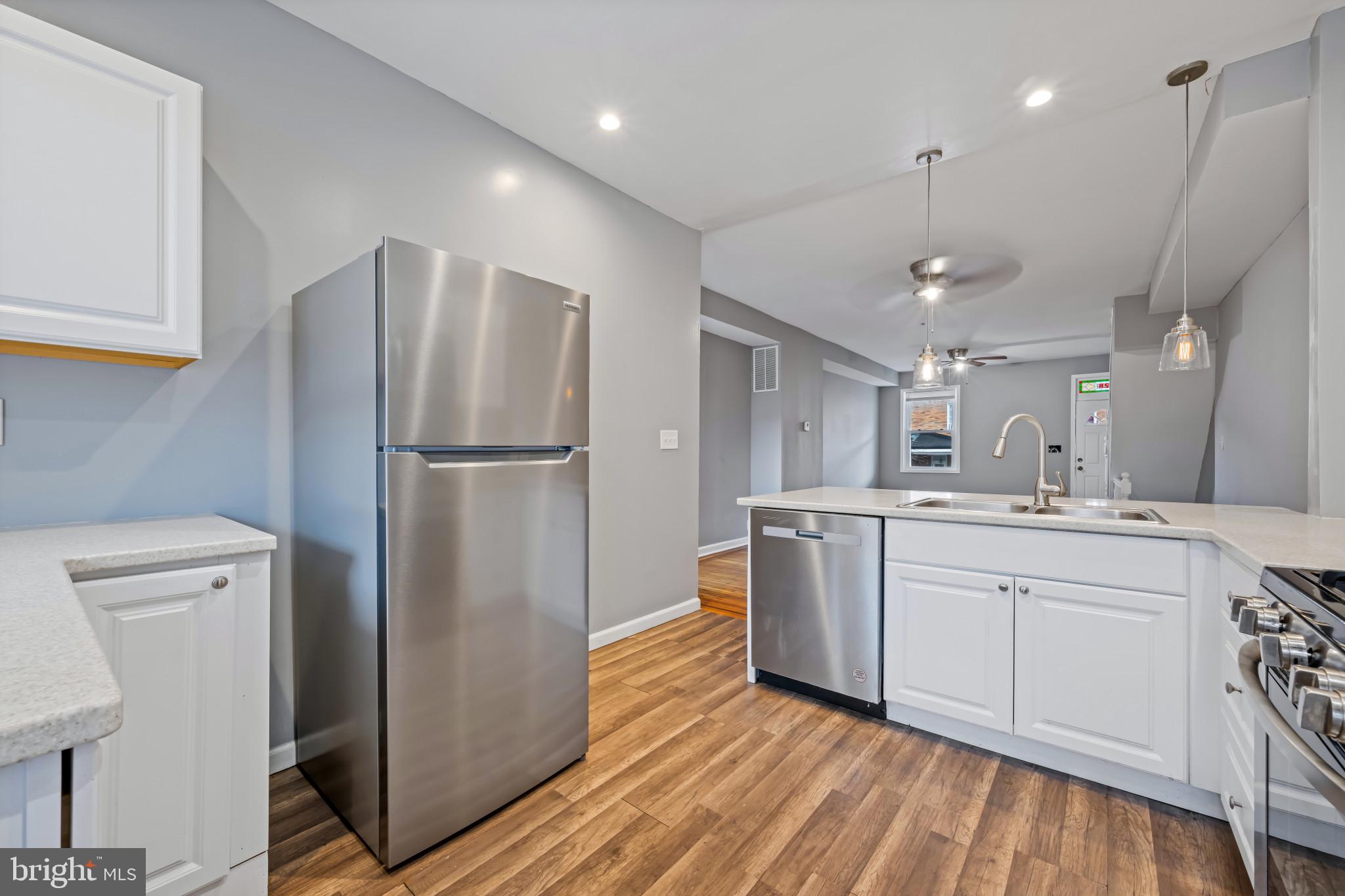628 Savage Street Baltimore, MD 21224 - Photo 12 of 45 a kitchen with a refrigerator sink and cabinets