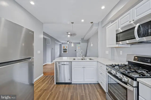 a kitchen with stainless steel appliances granite countertop a stove a microwave and white cabinets