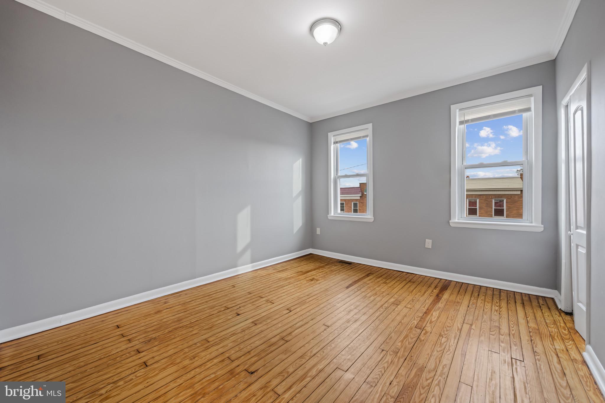 628 Savage Street Baltimore, MD 21224 - Photo 15 of 45 an empty room with wooden floor and windows