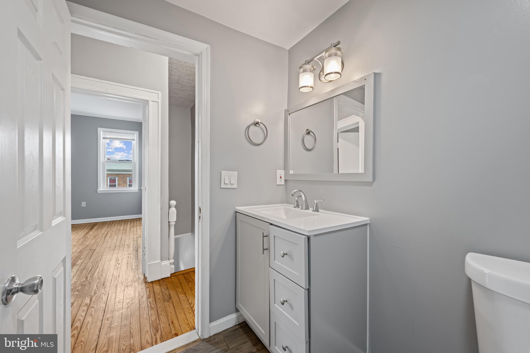 628 Savage Street Baltimore, MD 21224 - Photo 18 of 45 a bathroom with a sink a light fixture and a mirror