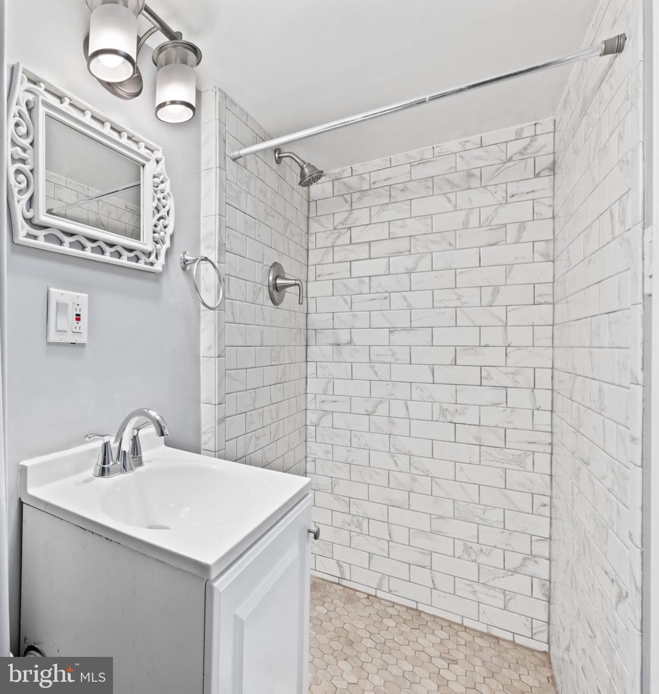 628 Savage Street Baltimore, MD 21224 - Photo 26 of 45 a bathroom with a sink a mirror and shower