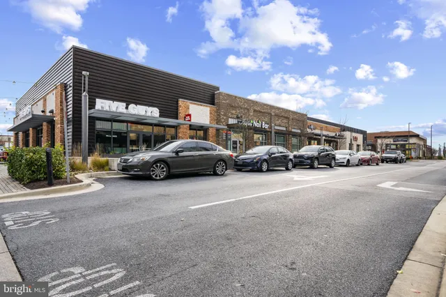 a view of a building with car parked on the road