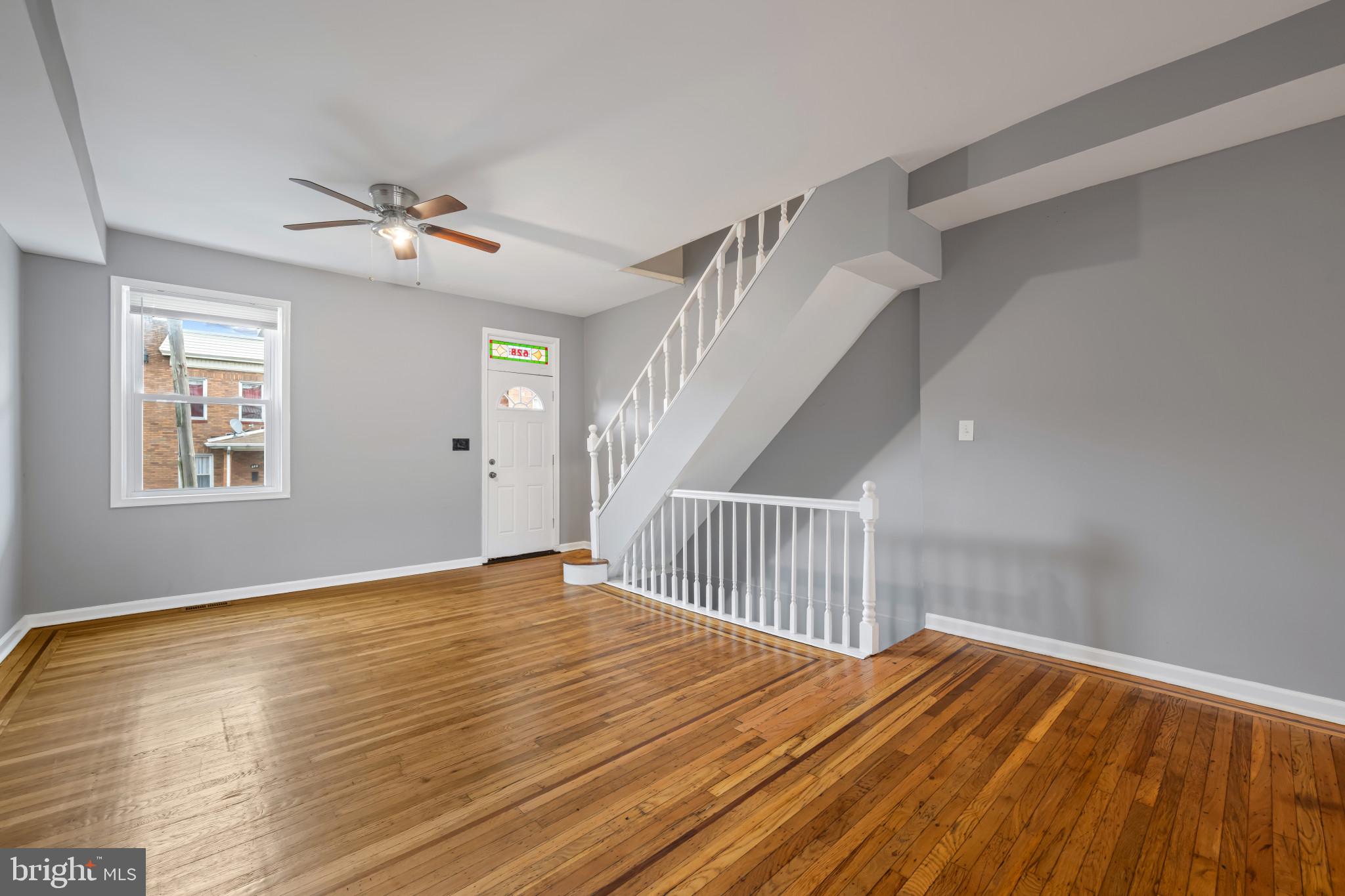 628 Savage Street Baltimore, MD 21224 - Photo 4 of 45 a view of a livingroom with wooden floor and white walls
