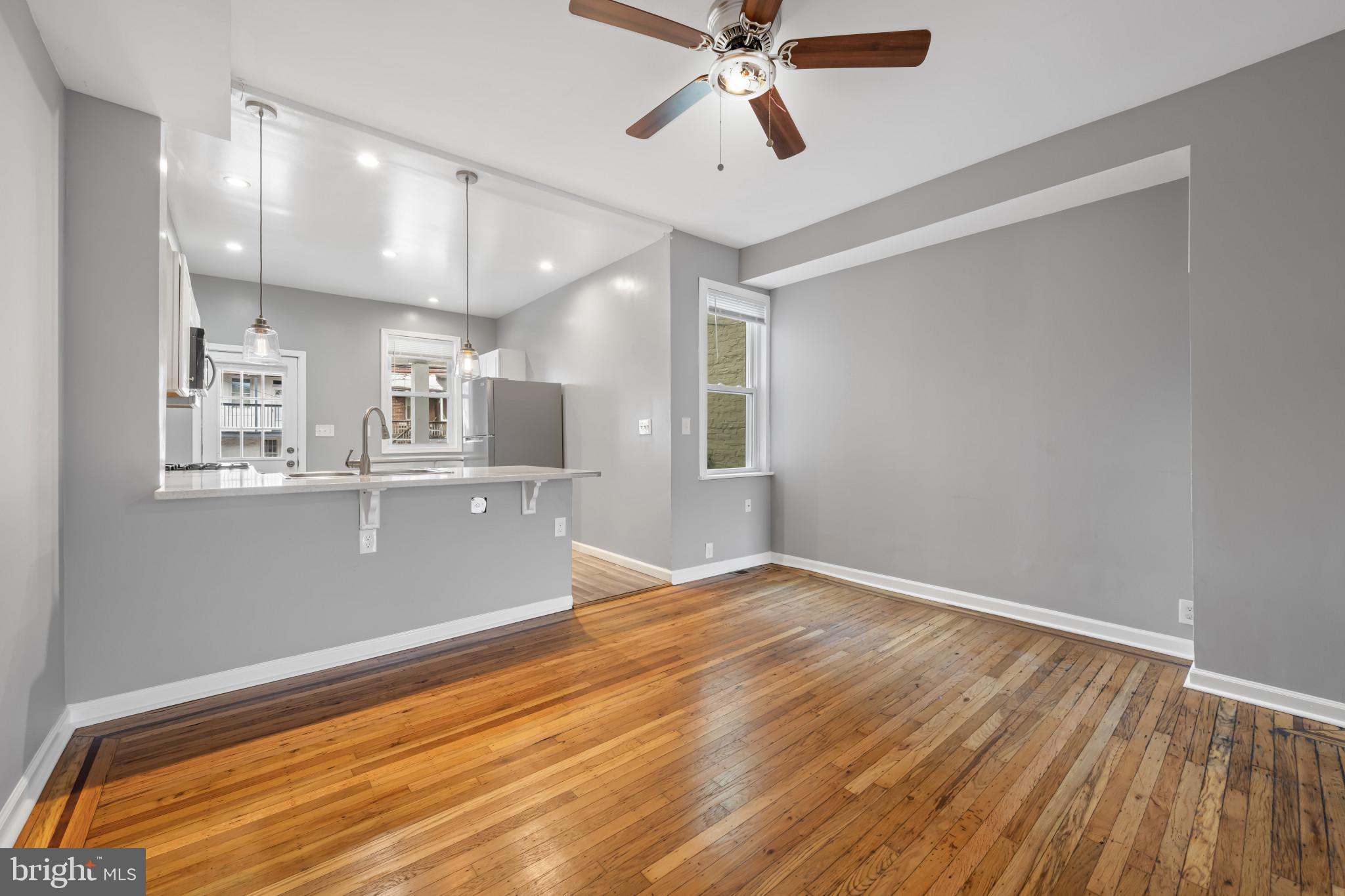 628 Savage Street Baltimore, MD 21224 - Photo 8 of 45 a view of an empty room with wooden floor and a window