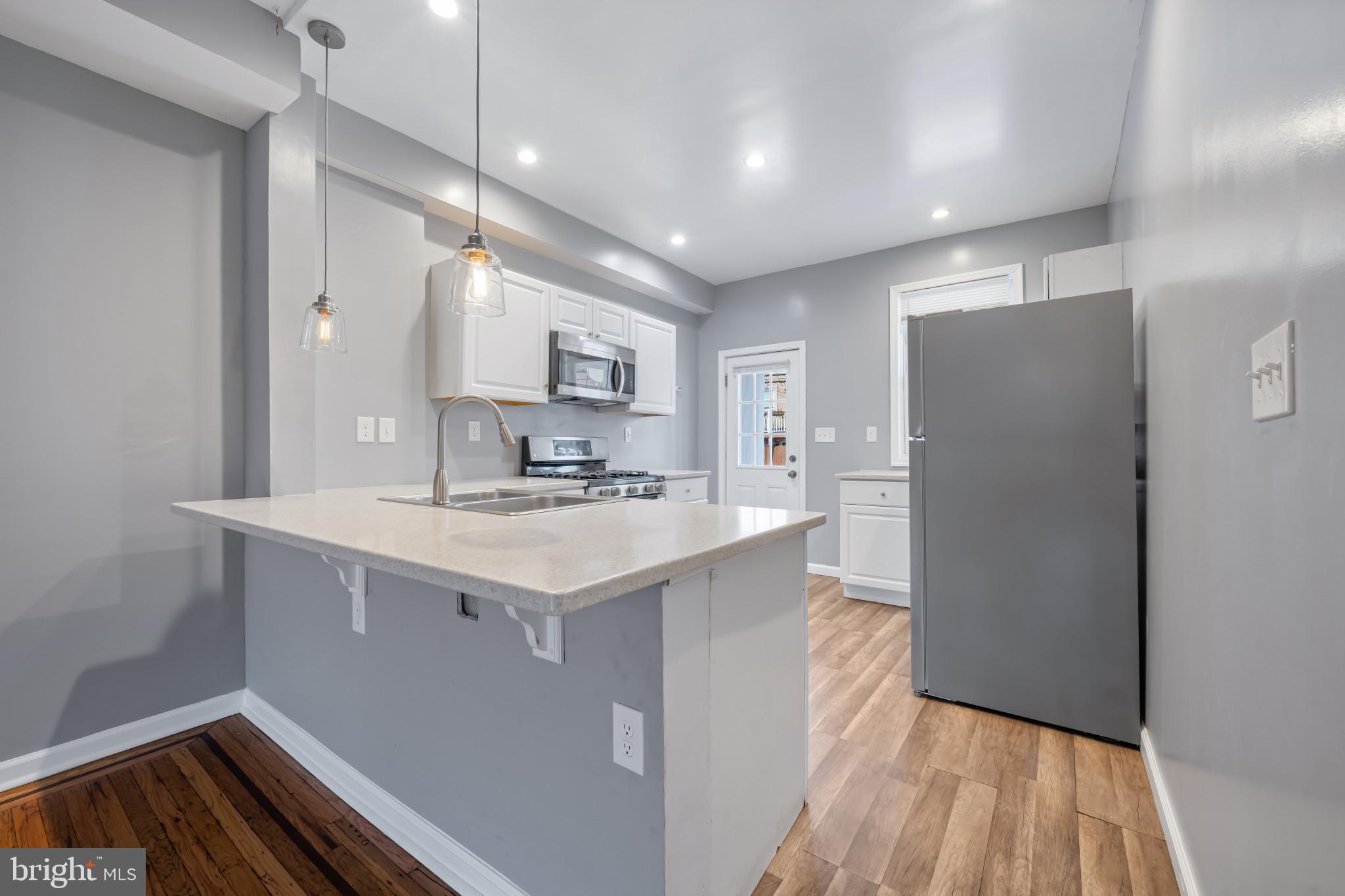 628 Savage Street Baltimore, MD 21224 - Photo 9 of 45 a kitchen with kitchen island a sink appliances and cabinets