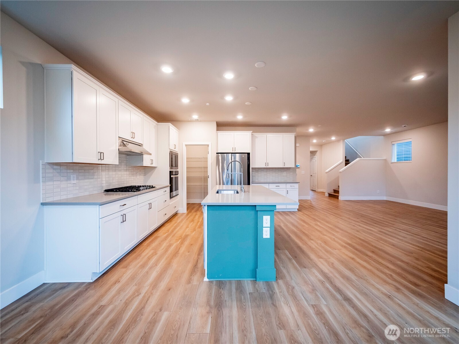 5393 Century Place Northeast Lacey, WA 98516 - Photo 11 of 33 a large kitchen with kitchen island wooden floors and stainless steel appliances