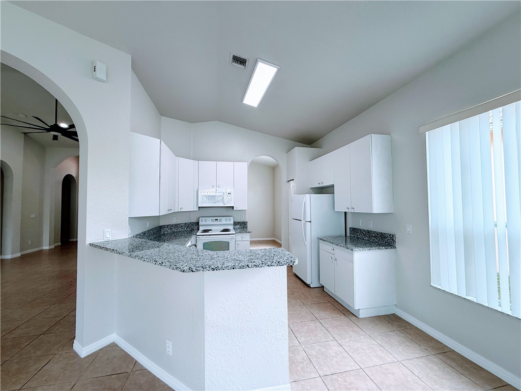 5837 Spanish River Road Fort Pierce, FL 34951 - Photo 12 of 34 a kitchen with kitchen island granite countertop a sink cabinets and stainless steel appliances