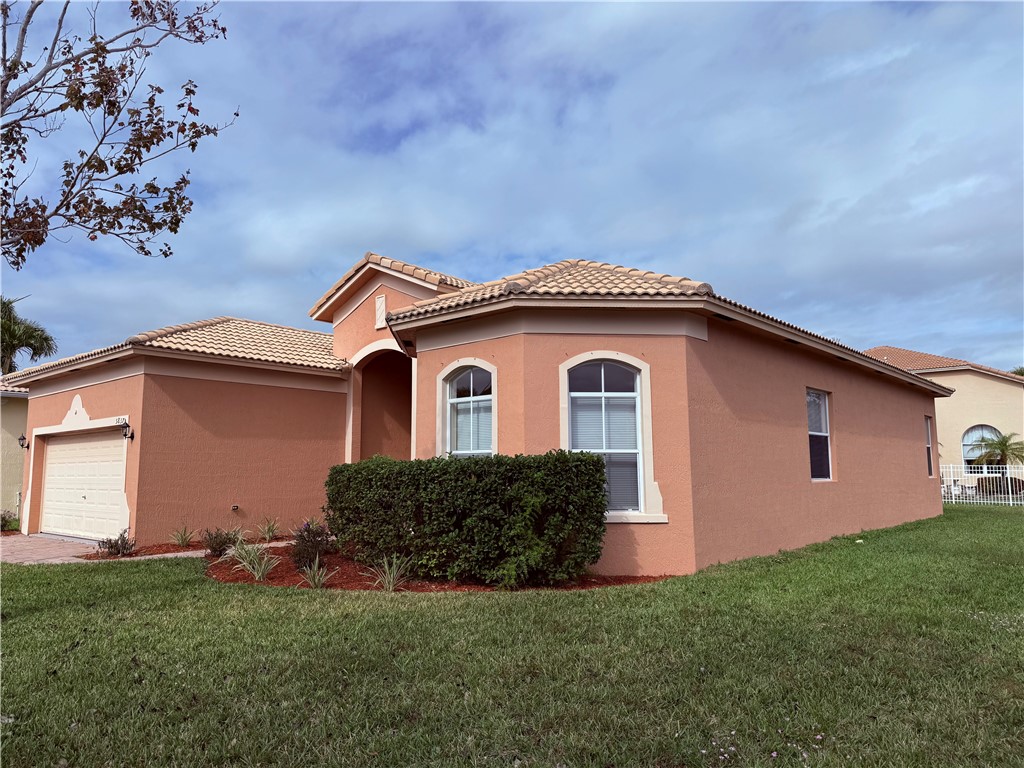 5837 Spanish River Road Fort Pierce, FL 34951 - Photo 2 of 34 a front view of a house with a garden