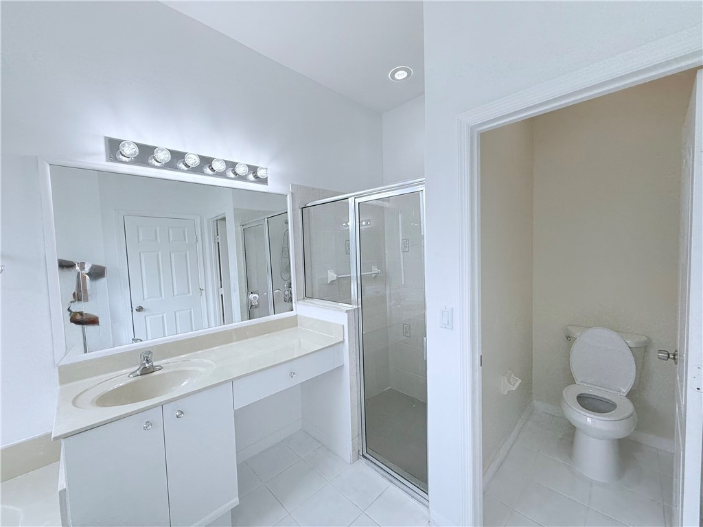 5837 Spanish River Road Fort Pierce, FL 34951 - Photo 22 of 34 a bathroom with a double vanity sink toilet and a mirror