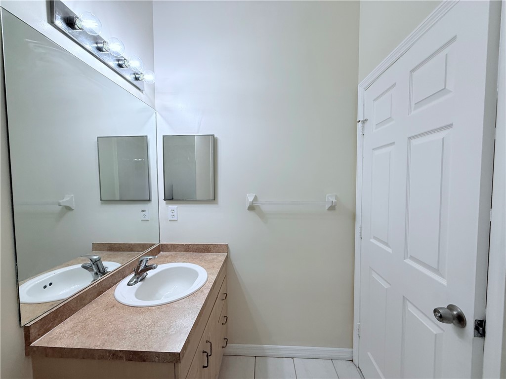5837 Spanish River Road Fort Pierce, FL 34951 - Photo 24 of 34 a bathroom with a granite countertop sink and a mirror