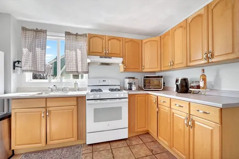 a kitchen with granite countertop white cabinets and white appliances
