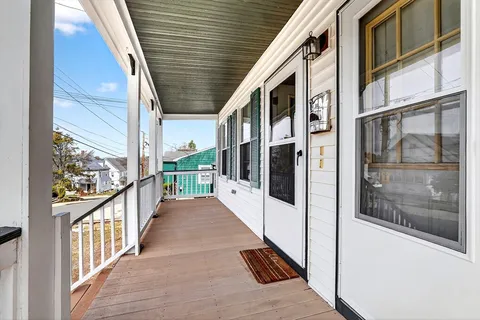 a view of a porch with wooden floor and iron stairs