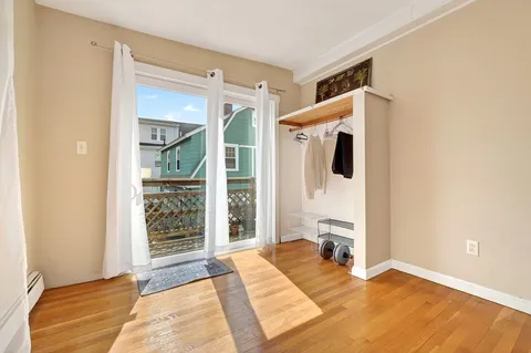 a view of a livingroom with wooden floor and a bed