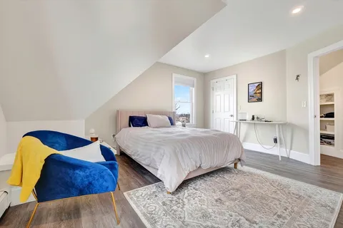 a bedroom with a bed and a painting on the wall