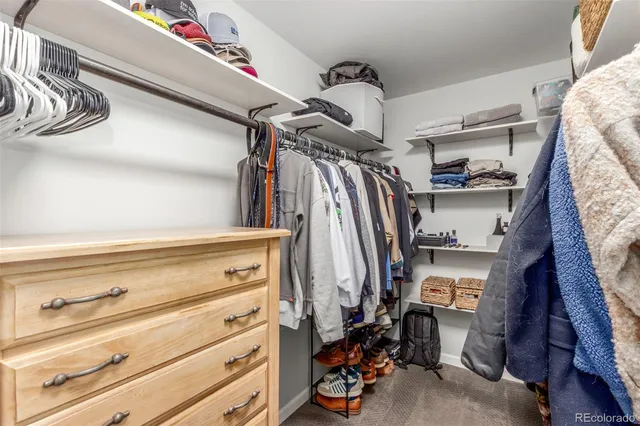 a view of walk in closet with clothes and shoes