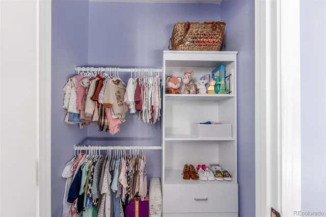 a view of walk in closet with clothes and shoes