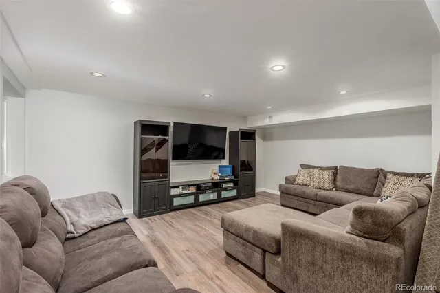 a living room with furniture and a flat screen tv with wooden floor
