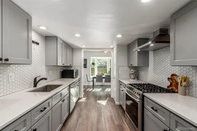 a kitchen with granite countertop a sink stove and cabinets
