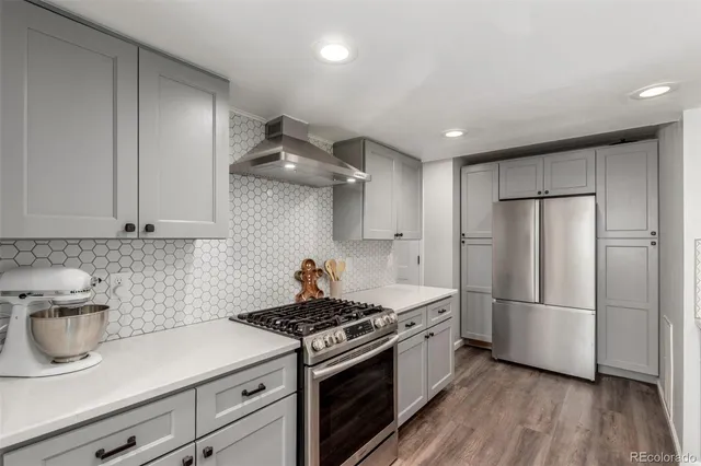 a kitchen with stainless steel appliances granite countertop a sink a stove and a refrigerator