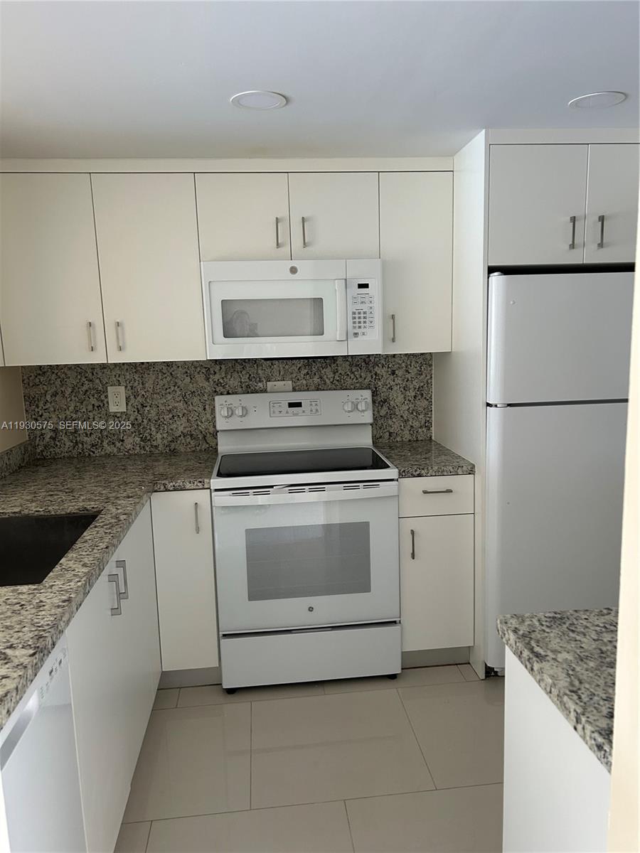 7910 North Colony Circle, Unit 209 Tamarac, FL 33321 - Photo 3 of 19 a kitchen with cabinets appliances and a sink