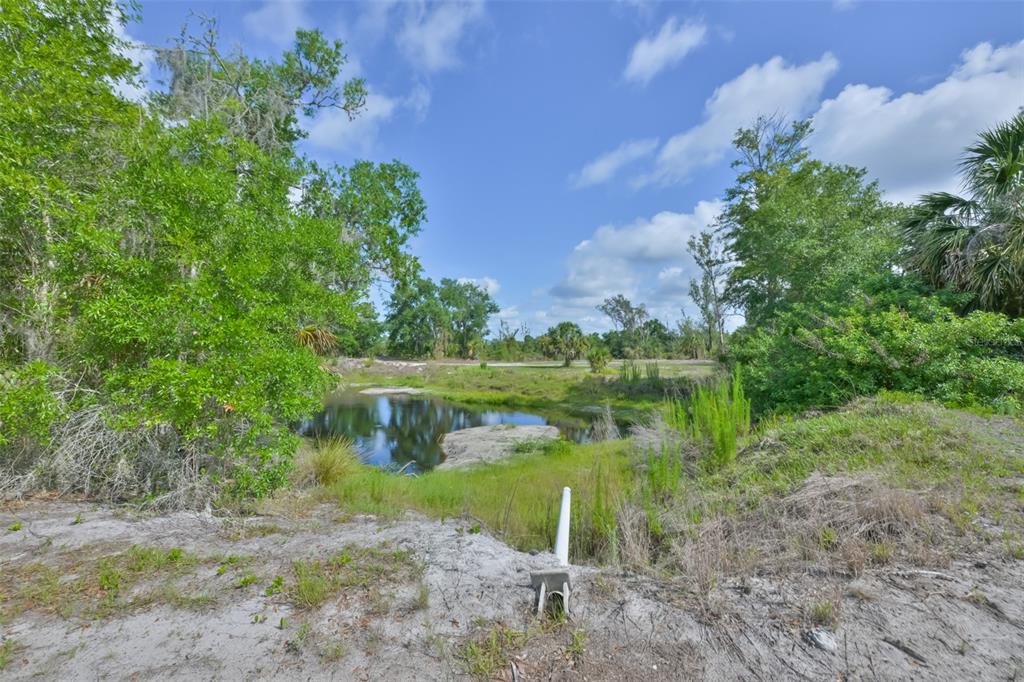 14451 Highland Road Wimauma, FL 33598 - Photo 45 of 80 a view of a lake with lawn chairs and a fountain