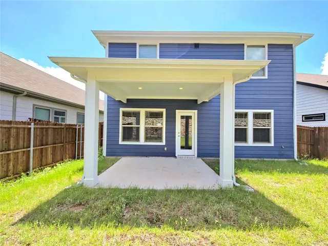 a view of a house with a yard and a large tree
