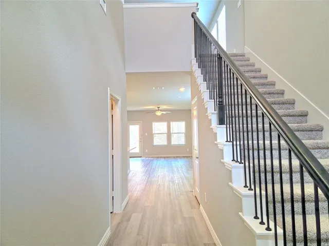 a view of a hallway with wooden floor and staircase