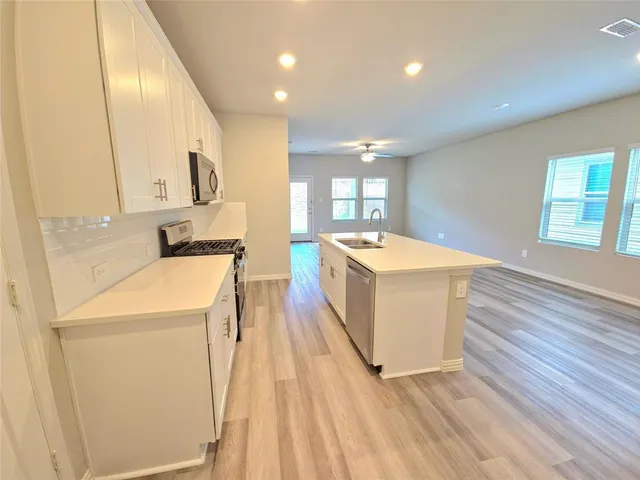 a room with a washer dryer and wooden floor
