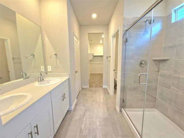 a spacious bathroom with a granite countertop sink a mirror a shower and a bathtub