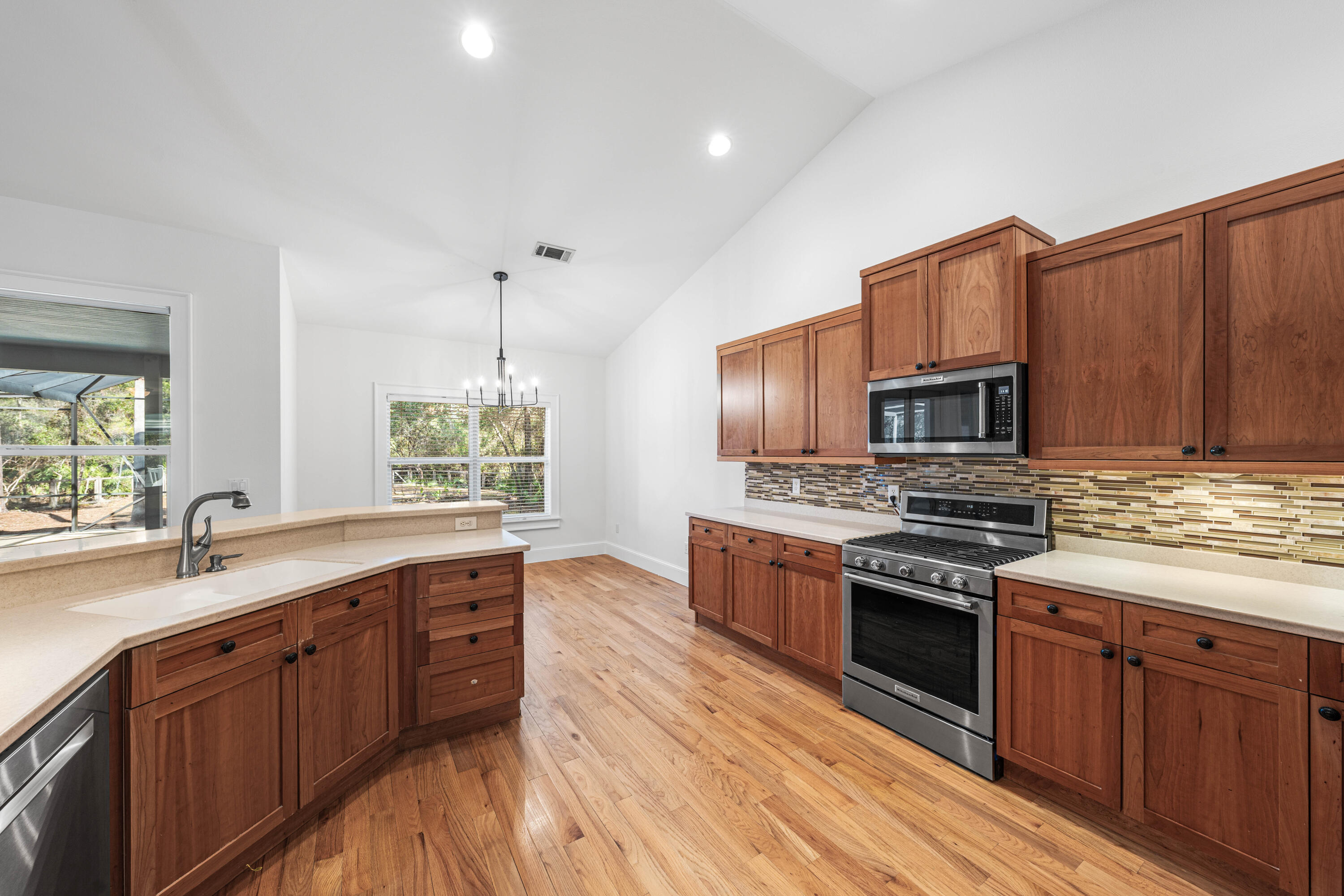 611 Amelia Lane Santa Rosa Beach, FL 32459 - Photo 23 of 59 a kitchen with stainless steel appliances granite countertop a stove a sink dishwasher a refrigerator and a microwave oven with wooden floor