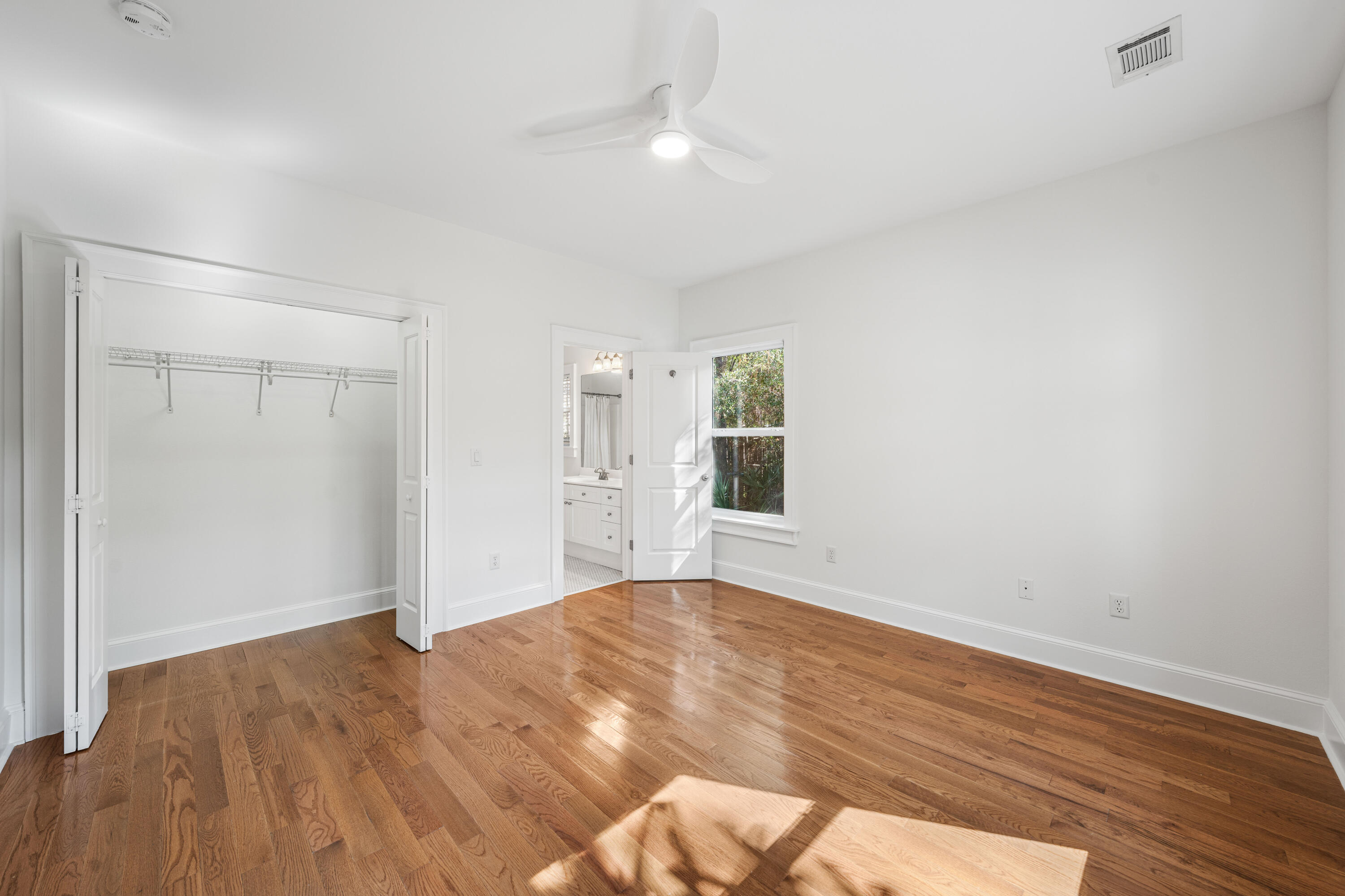 611 Amelia Lane Santa Rosa Beach, FL 32459 - Photo 33 of 59 a view of an empty room with wooden floor and a window