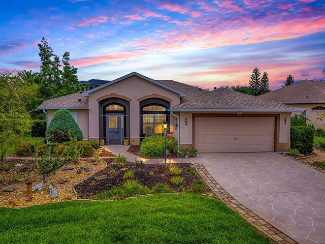 a front view of a house with a garden and yard