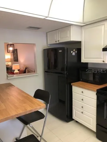 a kitchen with a refrigerator and cabinets