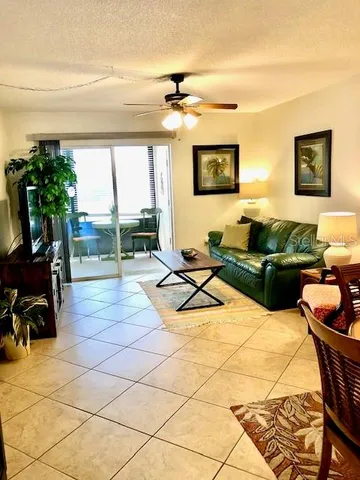 a living room with patio furniture and a floor to ceiling window