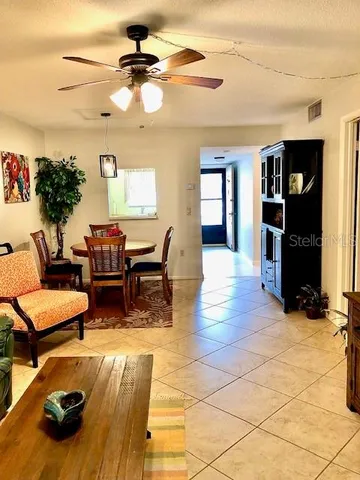 a living room with furniture and a dining table with kitchen view