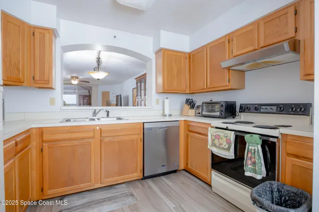a kitchen with stainless steel appliances granite countertop a sink a stove and cabinets
