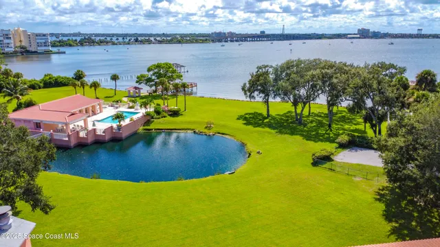an aerial view of a house with swimming pool patio and lake view