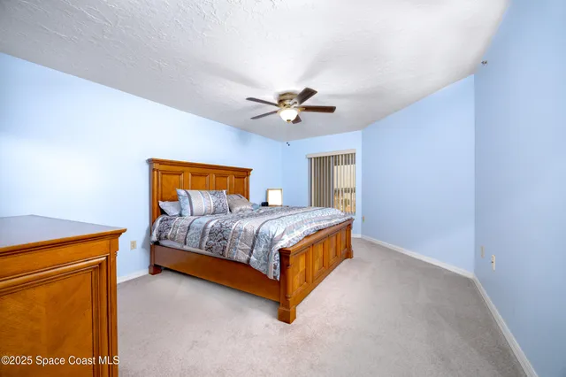 a bedroom with a bed and a ceiling fan