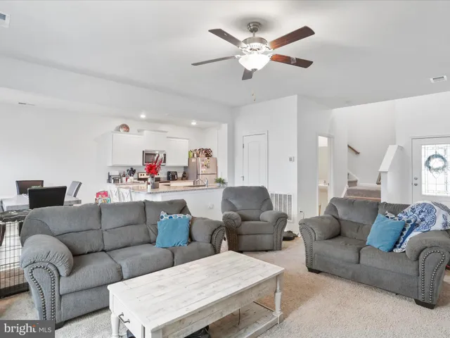 a living room with furniture and kitchen view